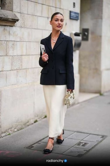 a woman in a black jacket and white skirt