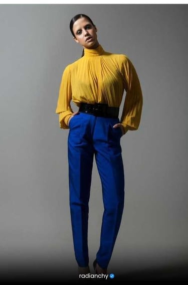 a woman in a yellow blouse and blue pants