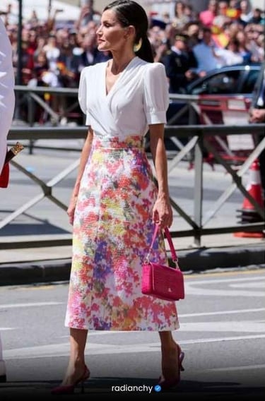 a woman in a white blouse and pink skirt