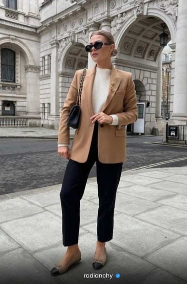 a woman in a tan blazer and black pants