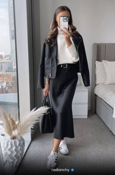 a woman in a black leather jacket and white sneakers