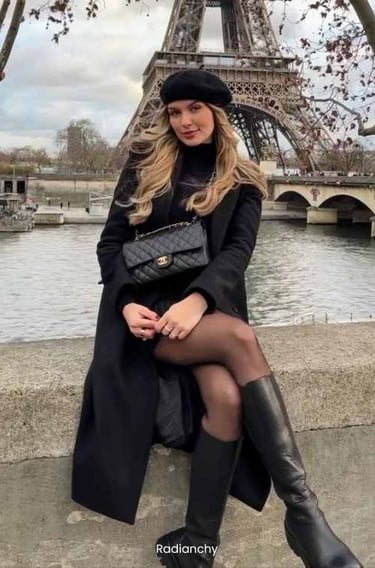 a woman in a black coat and boots is posing for a picture