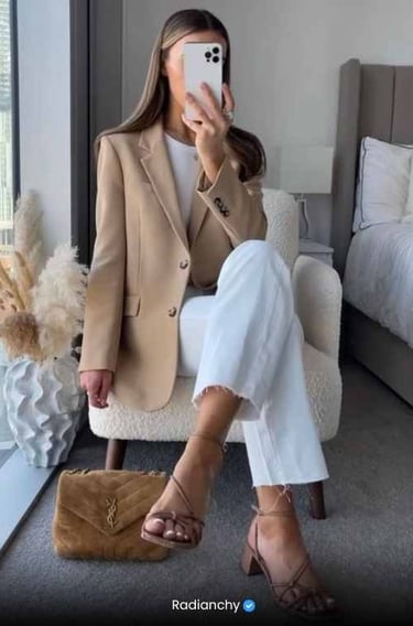 a woman in a tan blazer and white pants