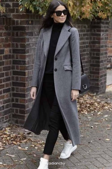 a woman in a grey coat and white sneakers