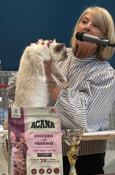 a woman is holding a cat in front of a microphone