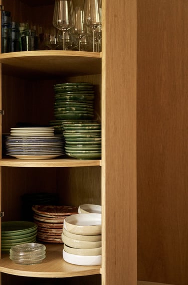 a kitchen cupboard with plates and glasses