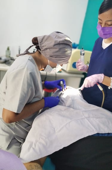 Dos dentistas profesionales atendiendo a paciente en consultorio dental