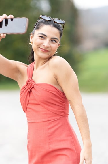 Vidéo pour professionnels en Provence, femme souriante se filmant au smartphone en extérieur, ambian