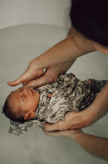 bain enveloppé bébé avec mains de papa