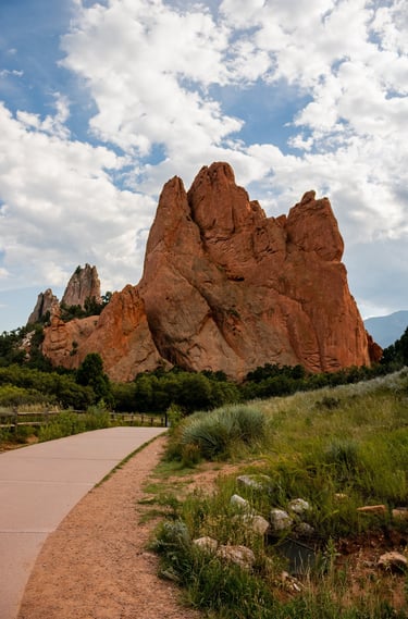 a paved path with a paved path leading to a mountain, Garden of the Gods