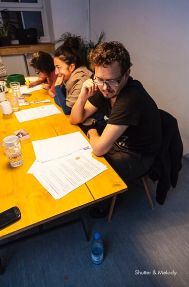 Ein Mann sitzt an einem Schreibtisch und liest Lehrmaterial.
