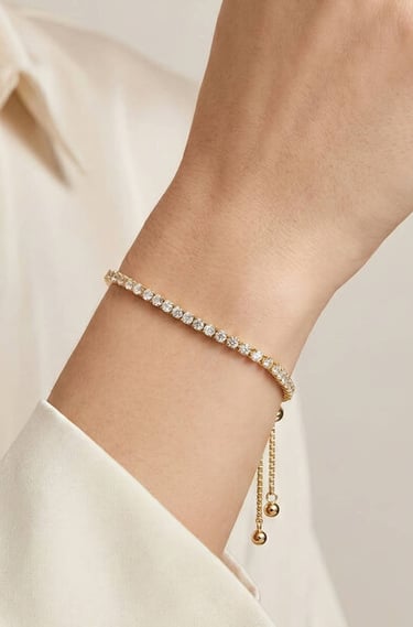 Elegante pulsera tipo tenis de oro y diamantes con cierre deslizante ajustable, lucida en la muñeca 