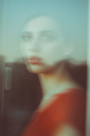 Femme au regard distant derrière la fenêtre 