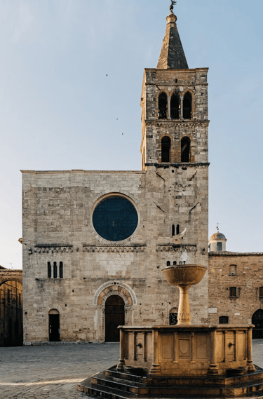 Facciata della chiesa di San Michele Arcangelo a Bevagna con la fontana in primo piano