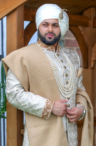 Portrait of Regal groom in traditional gold outfit, light and airy photo  