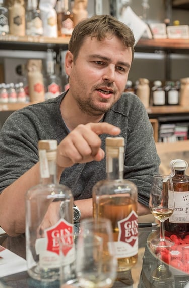 a man sitting at a table with bottles of alcohol