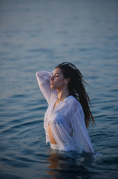 Sesión de fotos en la playa con modelo luciendo un vestido blanco y un collar llamativo