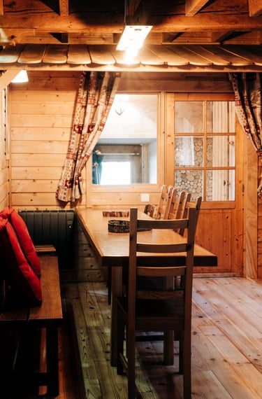 The wooden dining table in the Russian barn seen from the living room 