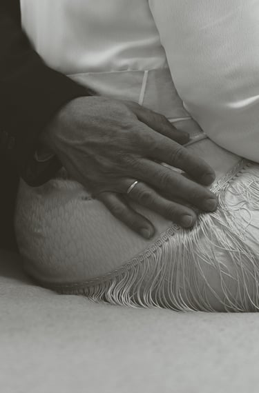 a man in a suit and tie is holding his hands on his knees