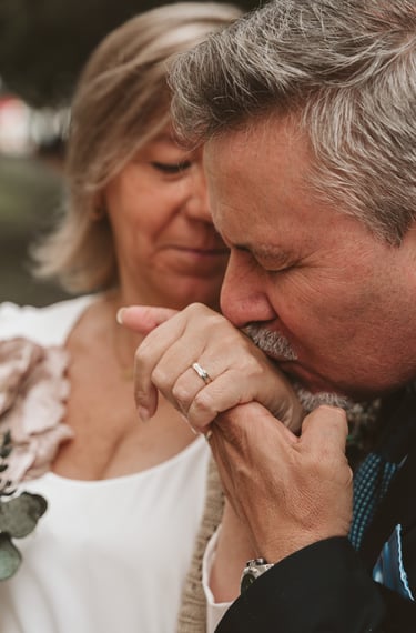 a man and woman holding hands and looking at each other