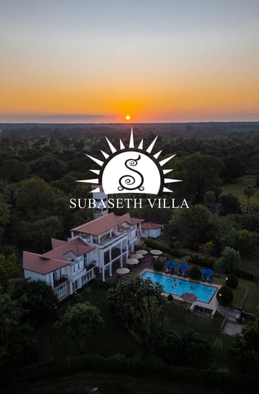a large house with a sun setting in the background