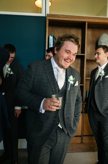 Best man sharing a drink with the groom during wedding morning preparations