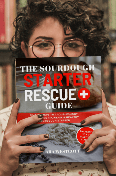 woman holding book the sourdough starter rescue guide