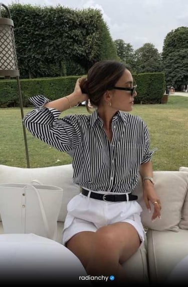 a woman in a striped shirt and white shorts
