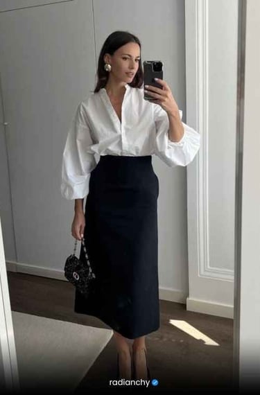 a woman in a white shirt and black skirt