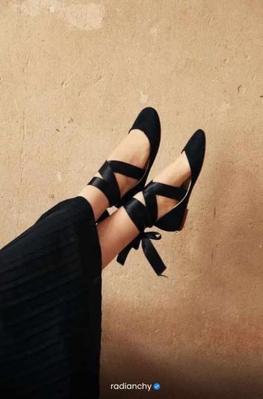 a person wearing black shoes and a black dress
