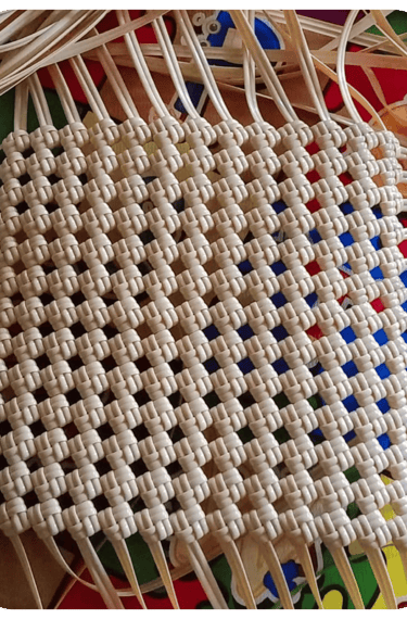 Base structure of a handmade woven bag using natural colored recycled plastic strips at Craftvitas Indonesia.