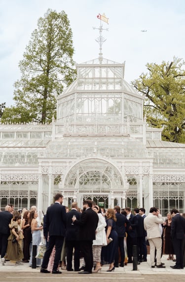 photograph of a wedding venue with wedding guests standing outside 