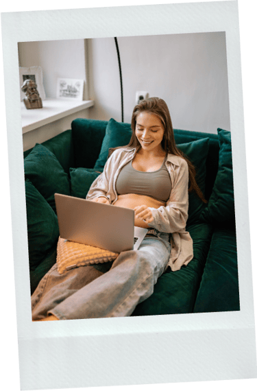 Polaroid van zwangere vrouw die in sport bh op de bank werkt