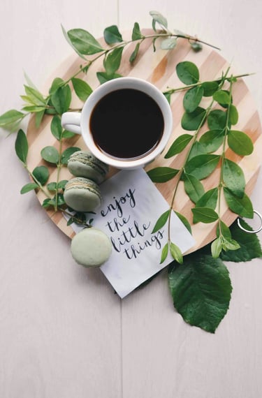 a cup of coffee, macaroons and a notepad