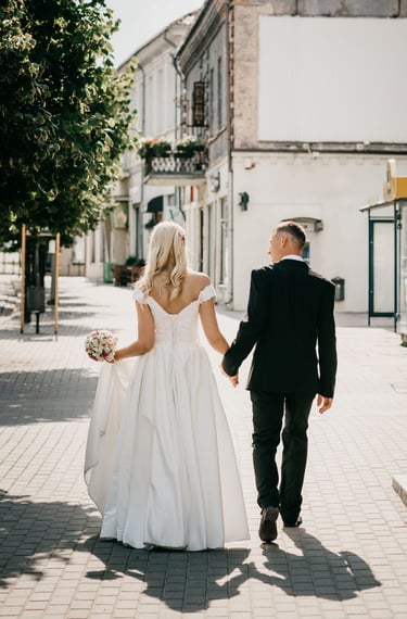 a bride and groom walking down the street