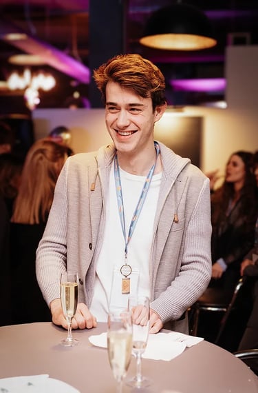 Invité souriant pendant une soirée d’entreprise à Luxembourg, coupe de champagne à la main.