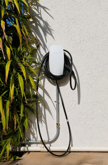 Tesla Wall Connector Level 2 residential EV charger installed on an exterior wall