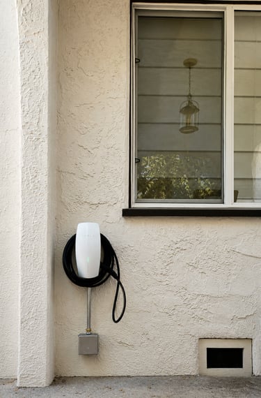 Tesla Wall Connector Level 2 residential EV charger installed on an exterior wall