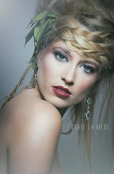 Woman with avant garde braided hairstyle with green leaves, bold red lipstick, dramatic eye makeup and statement earrings.