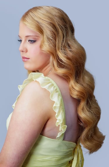 Bride with redhead hair styled in glam waves, wearing yellow dress, soft wedding makeup with neutral tones and long lashes.