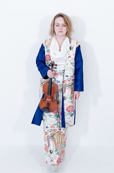 Portrait of Žydrė in traditional Japanese-inspired dress, eyes closed in contemplation while holding violin