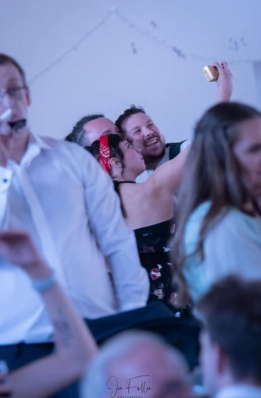 Smiling friends taking a selfie with a smartphone at a wedding reception party.