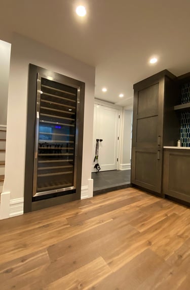 Professional basement finishing with modern flooring, and build in wine cooler refrigerator