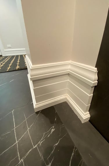 Finished basement with custom wall trim and tile flooring