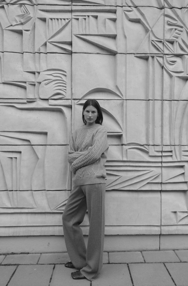 a woman standing in front of a wall with a large wall of art deco