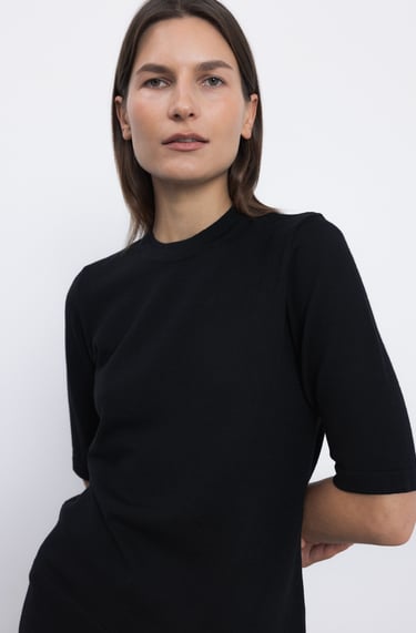 a woman in a black dress with a white background