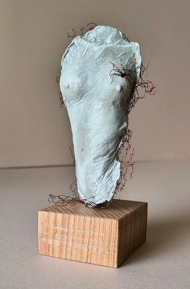 A plinth mounted sculpture of a female torso with wire around it and protruding through it.