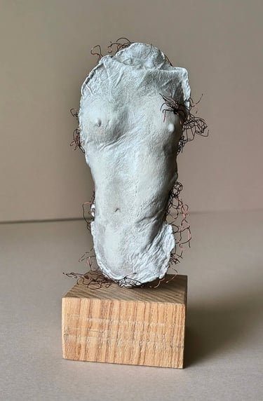A plinth mounted sculpture of a female torso with wire around it and protruding through it.