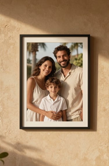 A framed lifestyle photograph of a happy family portrait hanging on a warm sand-colored wall inside a Southern European villa. Natural sunlight creates soft shadows and a cinematic, authentic feel.