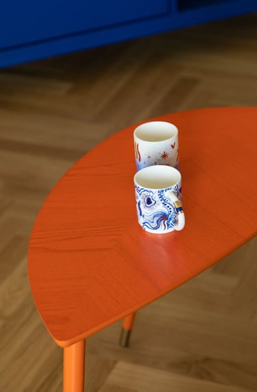 Stylizacja wnętrza: eklektyczny salon, pomarańczowy stolik i sztuka.